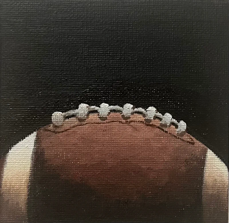This painting by Ben Young is a close up oil painting of an american football ball.