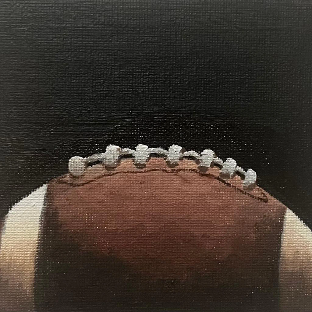 This painting by Ben Young is a close up oil painting of an american football ball.