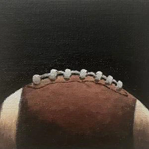 This painting by Ben Young is a close up oil painting of an american football ball.