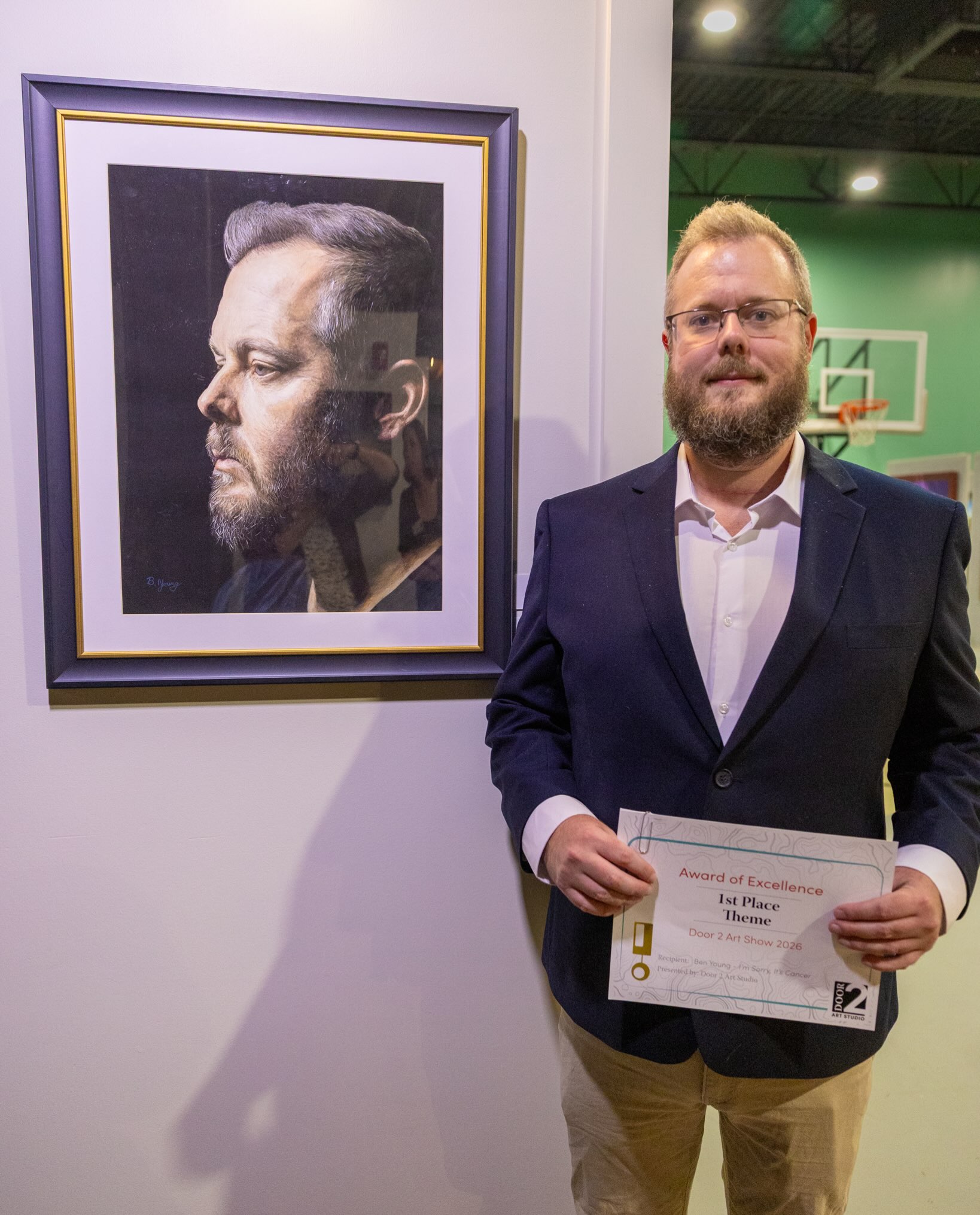 Ben standing with a first place aware in front of I'm Sorry, It's Cancer
